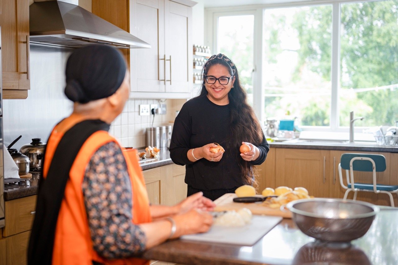 Two family members cooking together in the kitchen