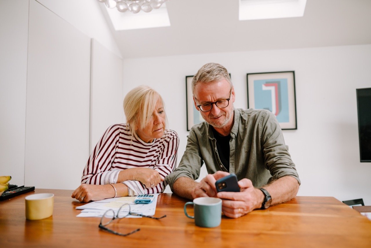 A couple reviewing paperwork together at the kitchen table